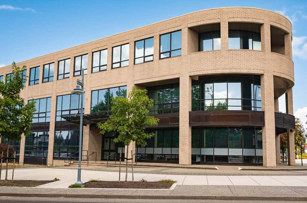 Modern suburban low rise office building. Architectural Exterior of Modern Low Rise Commerical Office Building Facade. Exterior of an office building with parking lot on a sunny summer day