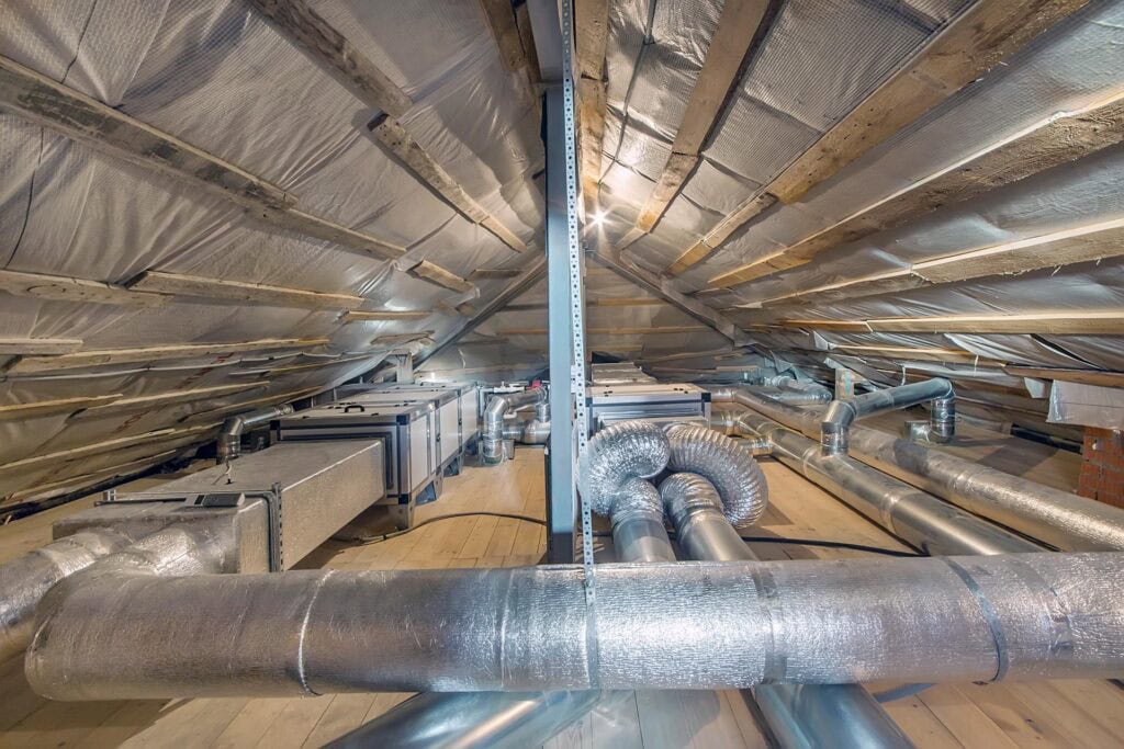 Whole house air ventilation and cleaning system. Ventilation pipes in silver insulation material on the attic